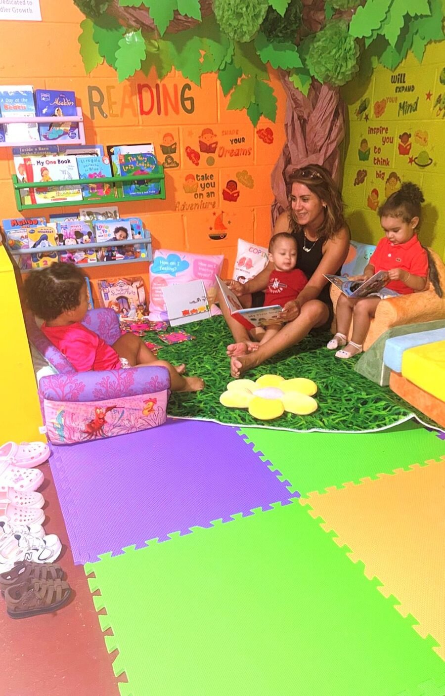 Miss Sandra leyendo con los niños sentados en sus sillones